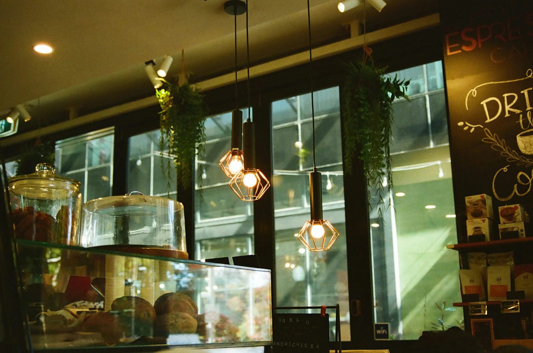 Warm pendant lights above the pastry counter in a Melbourne café